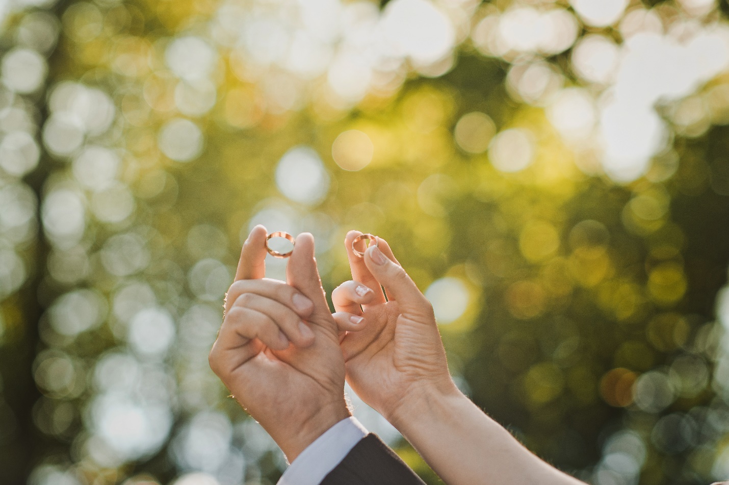 man and woman holding wedding rings