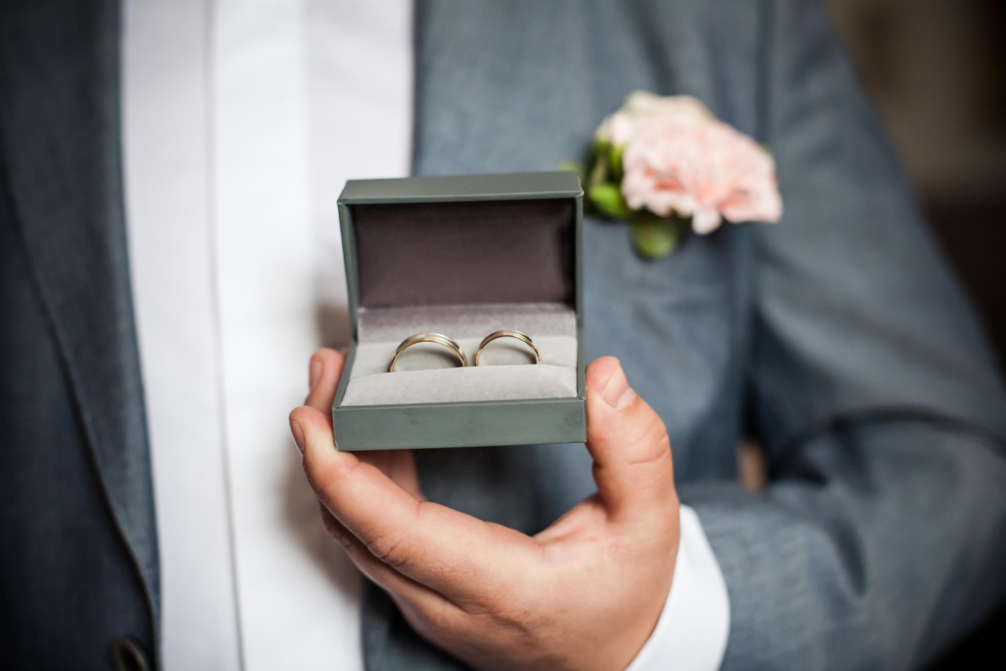 man holding two rings in box